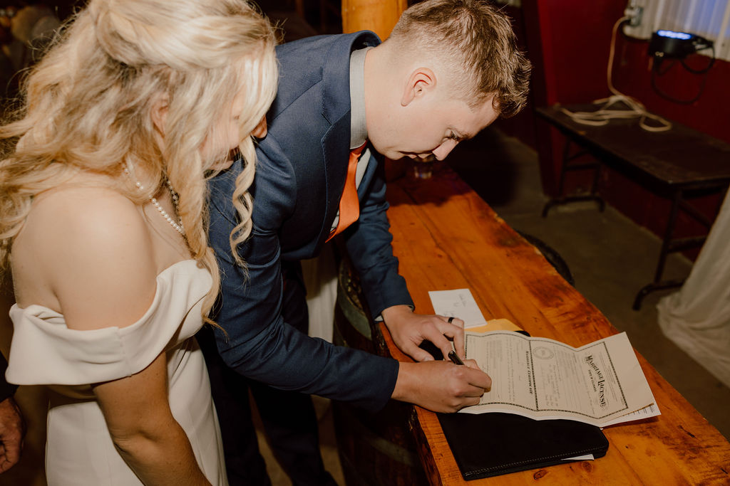 Bride and groom signing marriage license during Colorado micro wedding 