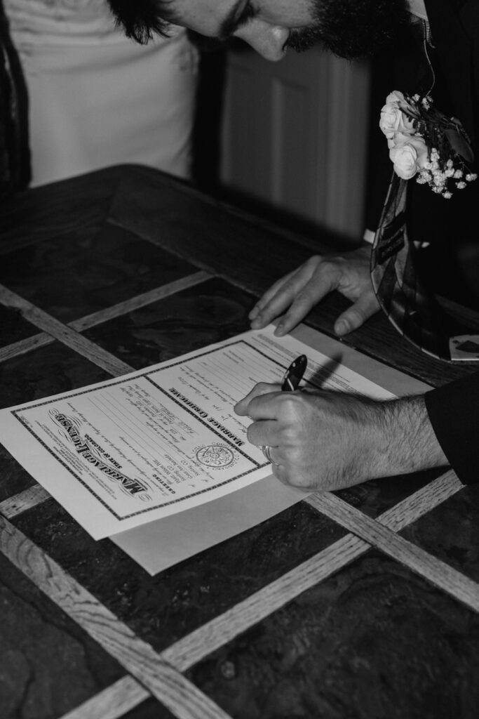 groom signing marriage certificate