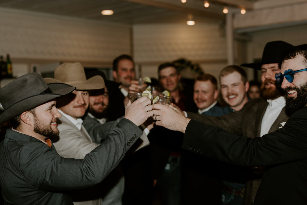 groomsmen toasting drinks during reception