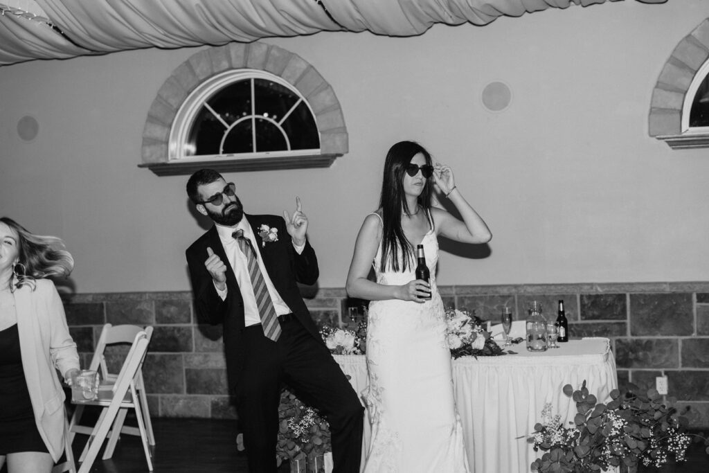 bride and groom wearing heart shaped glasses and dancing